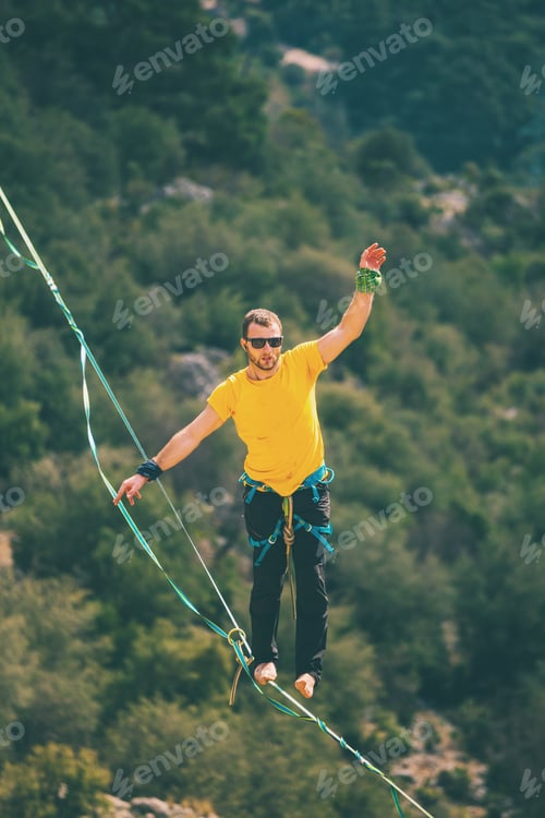 Preview: A Man Is Walking Along A Stretched Sling. Highline In The Mountains. Man Catches Balance