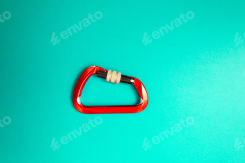 Preview: Red Carabiner With Clutch On A Blue Background. Equipment For Climbing And Mountaineering.