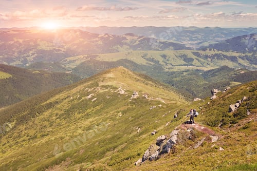 Preview: Hiker Standing On A Cliffs Edge. The Top Of The Mountain. Colorful Clouds In A Light Of Sunrise.