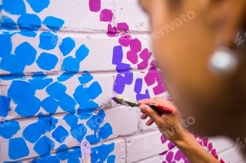 Visualização: O artista desenha em uma parede de tijolos. Mulher faz pinceladas. Artista de rua. Pintor. Arte moderna.