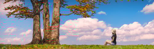 Preview: Woman Sitting Under The Tree On A Green Hill Against Blue Sky. Autumn Time.