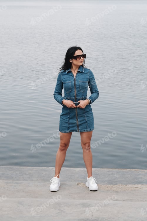 Preview: Portrait Of One Beautiful Brunette Girl Dressed In Jeans Denim Overalls Spends Leisure Time