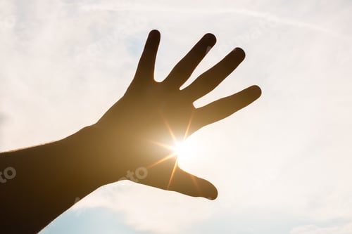Preview: Silhouette Of A Hand Against A Sunset. Sun Rays Between Fingers
