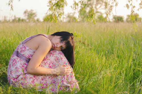 Preview: Beautiful Sad Girl Sitting Alone On The Meadow On Sunny Summer Day.