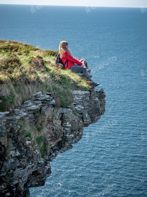 Preview: Young Woman Sitting On The Edge Of A Cliff At The Irish West Coast - Travel Photography