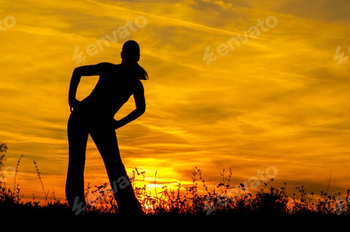 Vista previa: Silhouette Of The Slim Girl Stretching Out In The Nature At Sunrise.