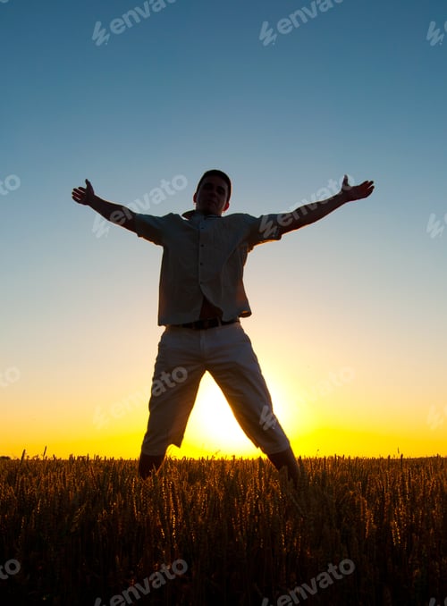 Preview: Silhouette Of Man Jumping High In The Wheat Field On Sunny Summer Day.