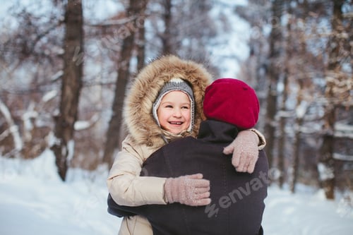 Preview: Happy Little Girl Hugging Her Mother In The Winter Forest