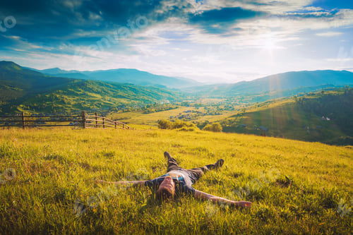 Preview: Tourist Lying On A Hill In A Fresh Green Grass And Enjoy Majestic Sunset Above Carpathian Mountain