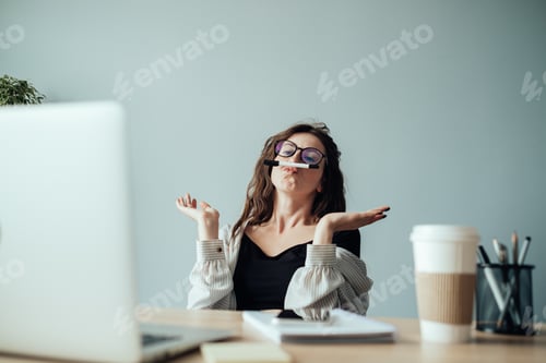 Preview: Funny Young Woman with Pen Between Lip and Nose