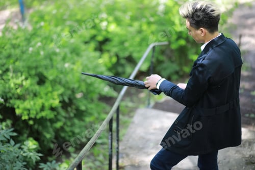 Preview: Spring Park In Rainy Weather And A Young Man With An Umbrella