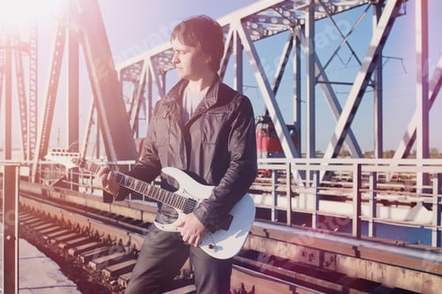 Preview: A Man With An Electric Guitar On The Railway. A Musician In A Leather Jacket With A Guitar On The