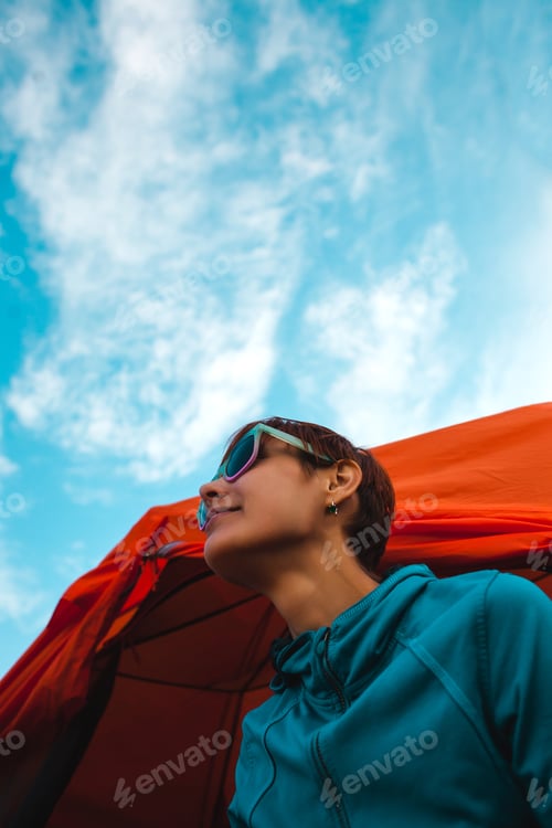 Preview: The Girl Is Sitting Near The Tent. A Smiling Woman Is Resting In Nature. Camping. Portrait Of A