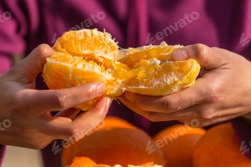 Preview: Oranges In Female Hands Close Up. Peeled Citrus Fruits. Woman Peels Oranges From Peel.