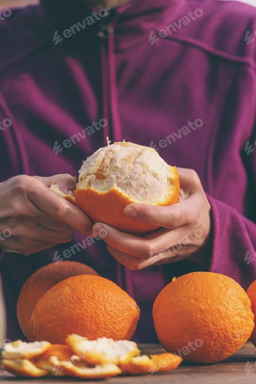 Preview: Oranges In Female Hands Close Up. Peeled Citrus Fruits. Woman Peels Oranges From Peel.