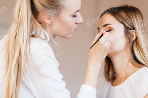Preview: Professional Makeup Artist Working With Beautiful Young Woman In White T-Shirt With Word "Less"