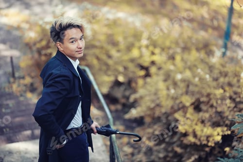 Preview: Autumn Park In Rainy Weather And A Young Man With An Umbrella