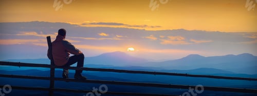 Preview: Man Sitting On A Wooden Fence And Enjoy Sunrise In Mountain Valley.