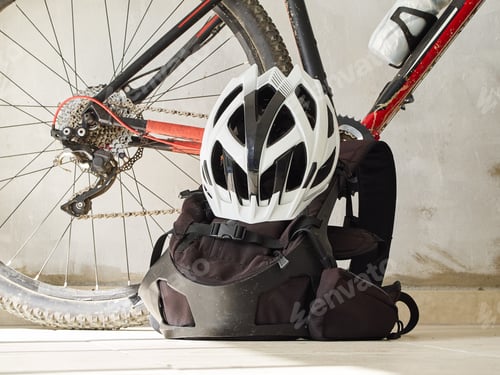 Preview: Mountain Bike, Backpack And Helmet On A Garage. Mountain Biking Equipment. Sport Lifestyle.