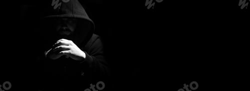 Preview: Man In A Black Hood And Smoke On A Black Background