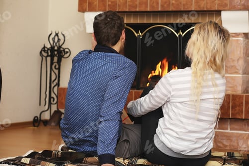 Preview: Couple Relaxing Together near Cozy Fireplace at Home