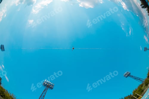 Preview: Highliner On The Background Of Blue Sky Makes A Move. A Man Is Walking Along A Stretched Sling View