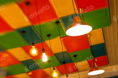 Preview: Round Stylish Lampshades Hang From Colorful Yellow, Green And Red Ceiling