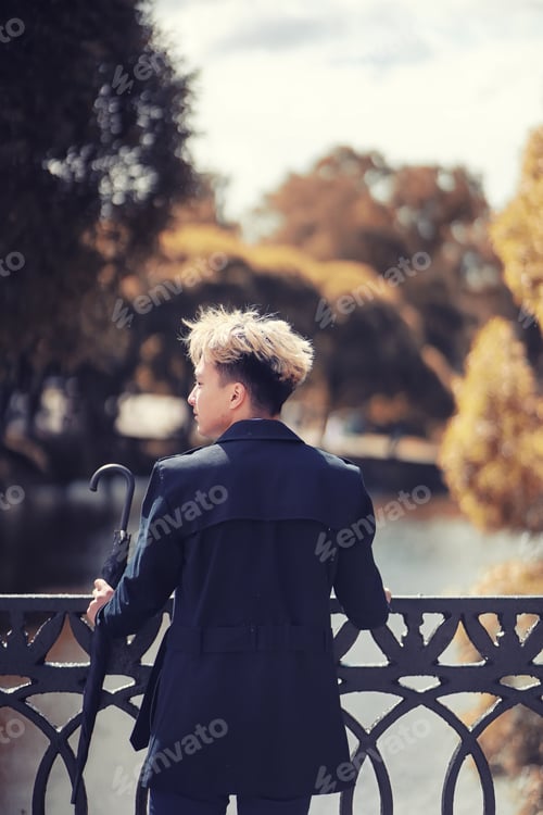 Preview: Autumn Park In Rainy Weather And A Young Man With An Umbrella
