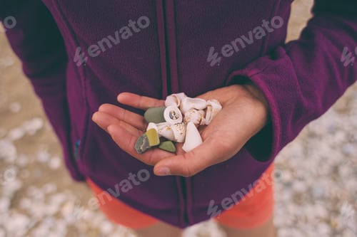 Preview: The Girl Collects Sea Stones And Shells. Small Pebbles In The Female Palm. Seashells In Hand.