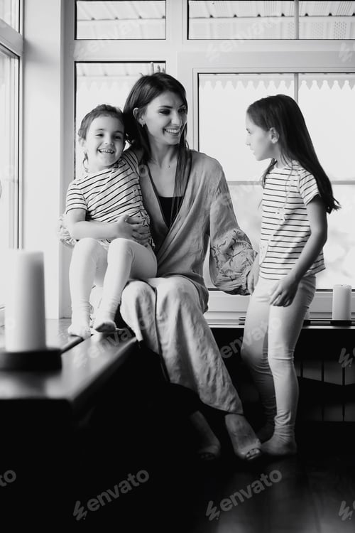 Vista previa: Hermosa familia joven con hijas en una sesión de fotos en un estudio blanco