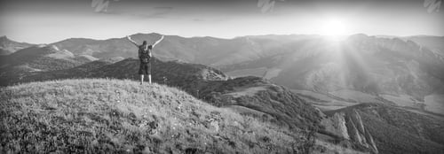 Preview: Hiker With Backpack Standing On Top Of A Mountain And Enjoying Sunrise. Black And White.