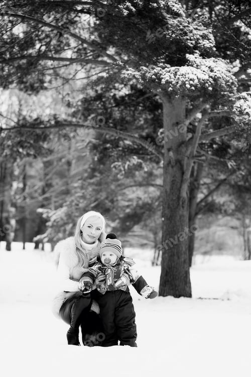Preview: A Young Mother Walks On A Winter Day With A Baby In Her Arms In The Park