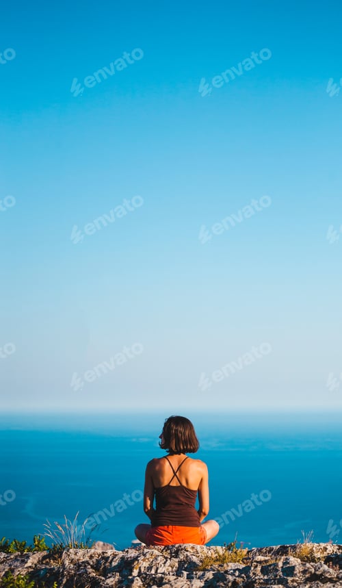 Preview: A Girl Is Sitting On Top Of A Mountain At Sunset. A Woman Is Engaged In Yoga And Sits In A Lotus
