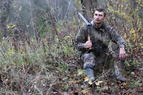 Preview: A Man In Camouflage And With Guns In A Forest Belt On A Spring Hunt