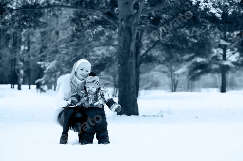 Preview: A Young Mother Walks On A Winter Day With A Baby In Her Arms In The Park