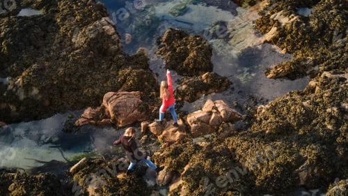 Preview: Two Girls In Ireland Climb Over The Rocky Oceanfront Of Malin Head - Travel Photography