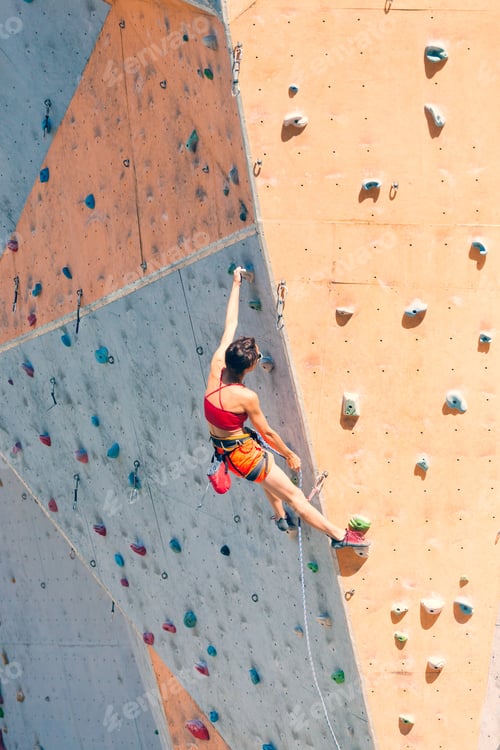 Preview: Training At The City Climbing Gym. A Strong Woman Climbs A Climbing Route On Artificial Terrain