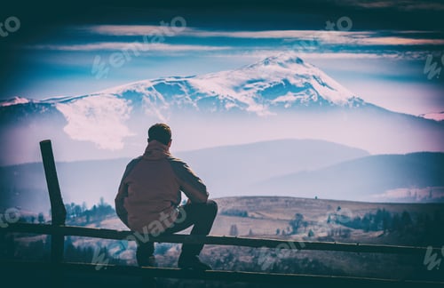 Preview: A Hiker Sitting On A Wooden Fence And Enjoy Mountain Valley With Snow-Capped Peak On A Skynine