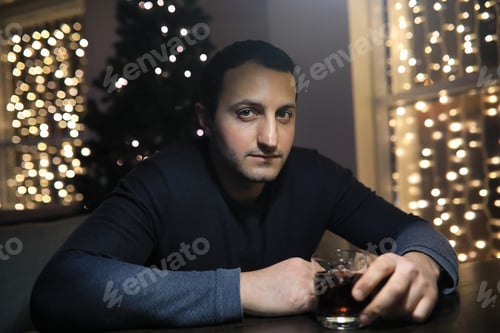 Preview: Man With Glass Of Whisky In Pub On Night
