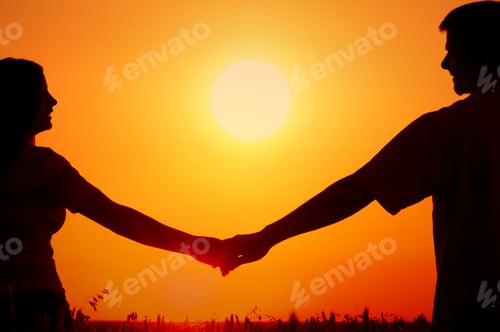 Preview: Silhouettes Of Happy Smiling Young Couple In Wheat Field At Summer Sunset.