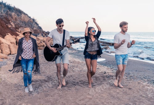 Preview: Group Of Young And Cheerful Friends Walking On Beach, One Man Is Playing Guitar. Dancing And