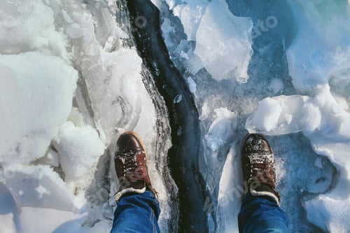 Preview: Male Legs In Shoes Standing On The Crack In The Ice