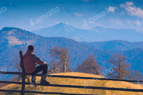 Preview: Man Sitting On A Wooden Fence And Contemplates The Carpathian Mountain Valley. Carpathians