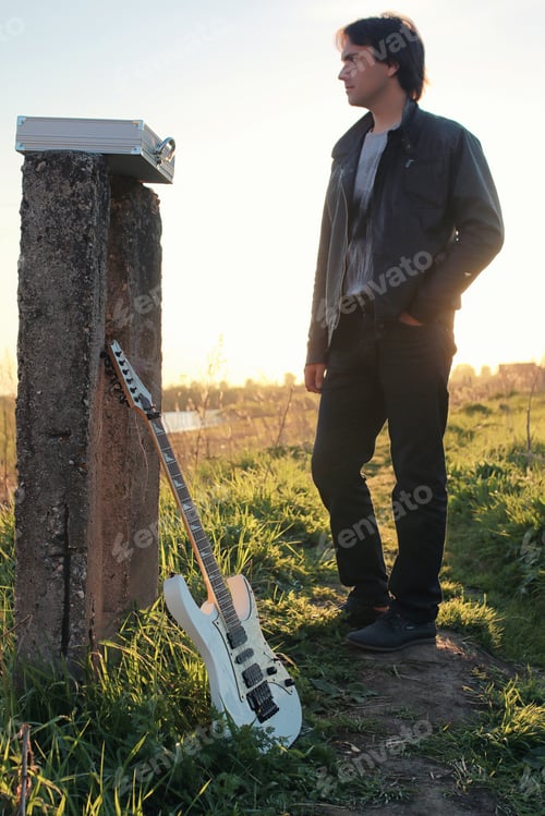 Preview: A Man With An Electric Guitar In The Industrial Landscape Outdoors