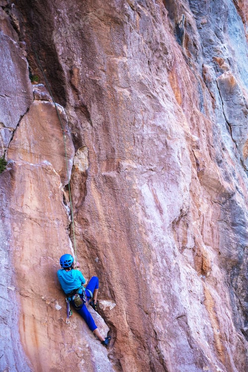 Preview: A Woman In A Helmet Climbs A Beautiful Blue Rock. Climbing Protective Equipment. Safety In