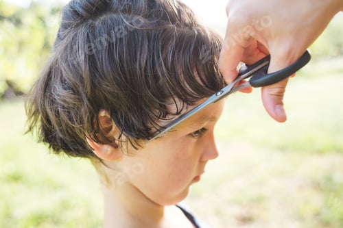 Preview: A Woman Cuts The Hair Of A Child In The Yard Of The House, Mom Cuts Her Son'S Hair Near The House