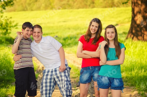 Preview: Four Teenage Friends Posing On The Meadow On Sunny Spring Day.