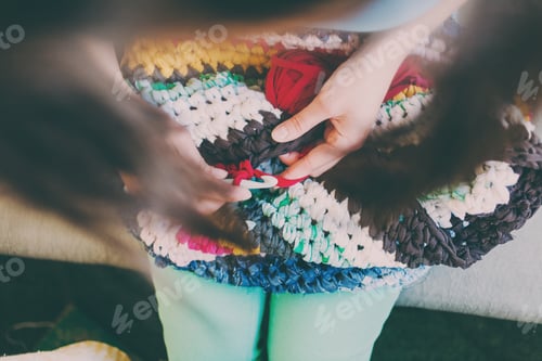 Preview: The Woman Is Knitting Crocheted Out Of Thick Yarn. Yarn From Old Clothes. Rug Of Homemade Thread