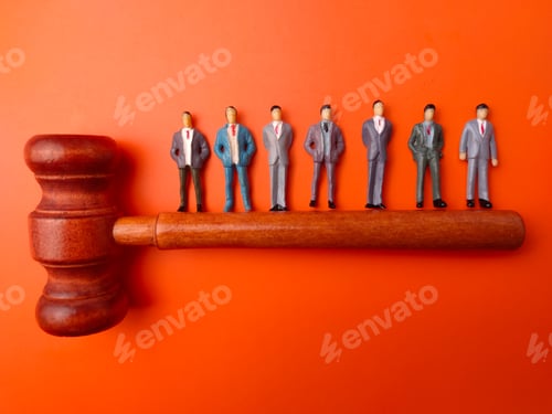 Preview: A high-angle conceptual studio shot featuring a row of miniature businessman figurines standing befo