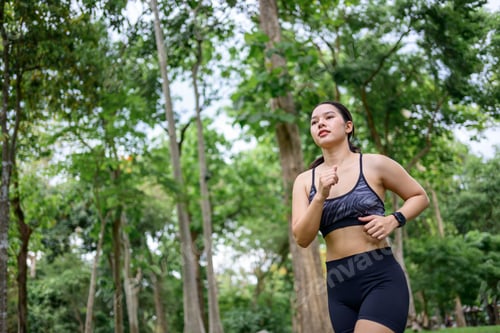 Preview: Young woman jogging in park for health and fitness